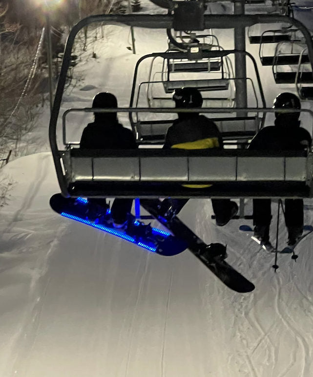 Snowboard with blue LED lights hanging beneath a chairlift at night, supplied with Trung L.’s review